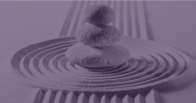Stacked stones in a raked sand garden with a purple overlay — stillness and intentional rest after a season of momentum